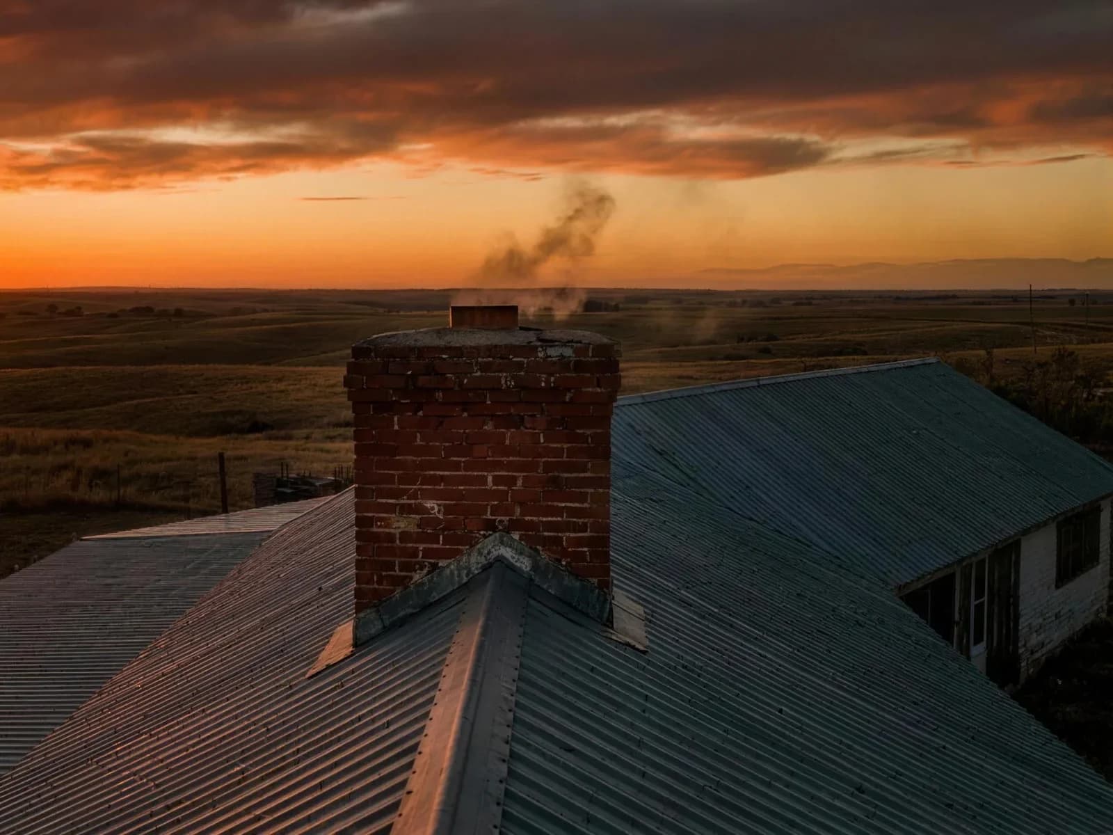 Chimney sweep inspecting a brick chimney on a Texas Panhandle rooftop